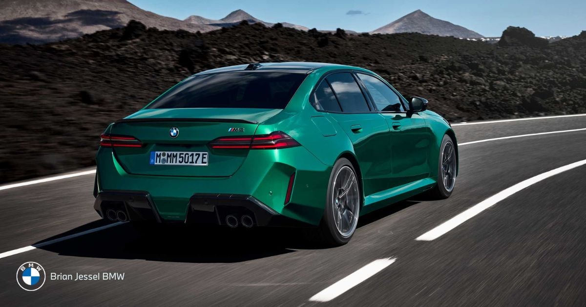 BMW M5 driving on a scenic road, showcasing performance and comfort for long-distance road trips
