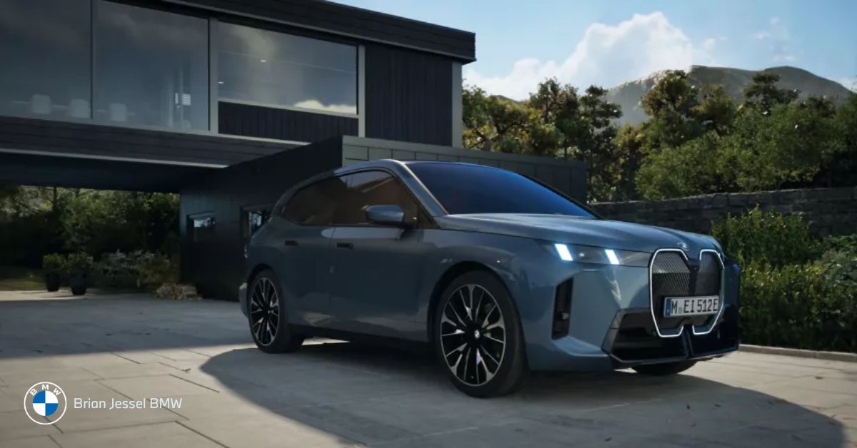 BMW iX electric SUV parked outside modern home, showcasing sleek design, advanced technology, and quiet luxury.