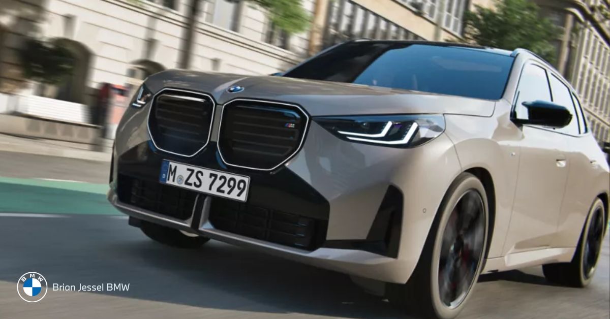 Silver BMW X3 M50 drives through city streets, combining compact SUV proportions with confident performance styling