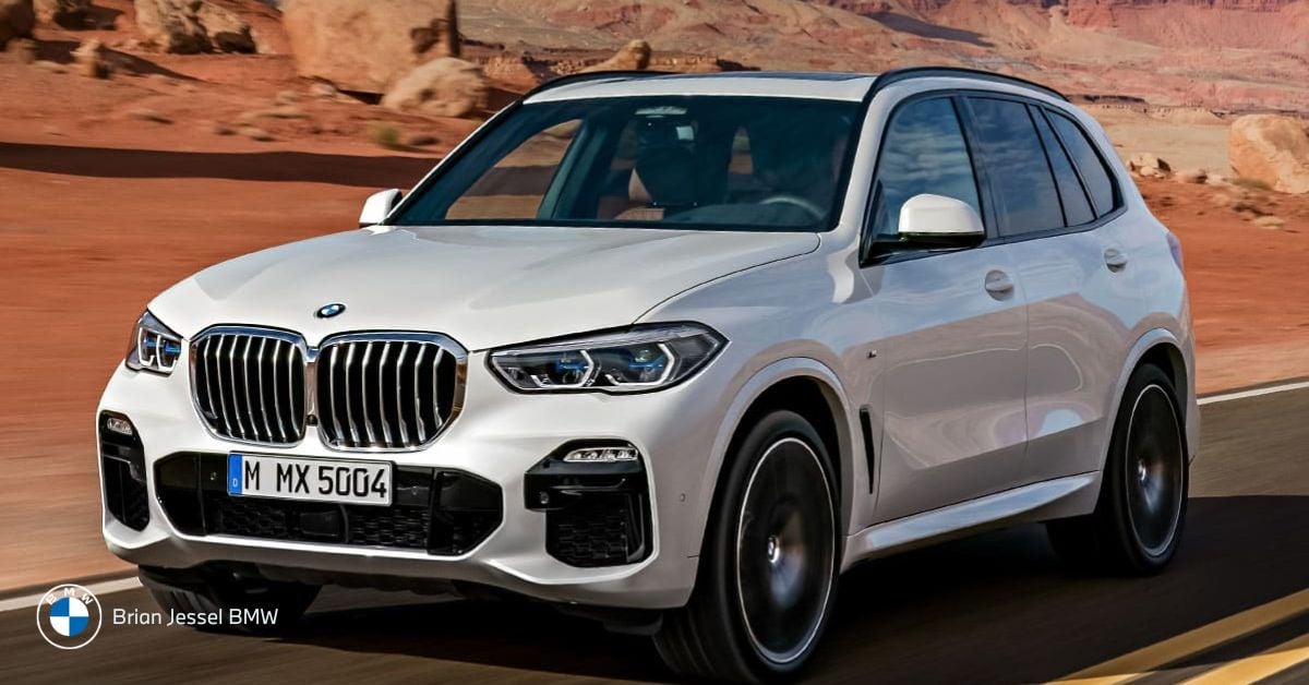 White BMW X5 drives through desert landscape, showcasing premium midsize SUV design, comfort, and long-distance capability.