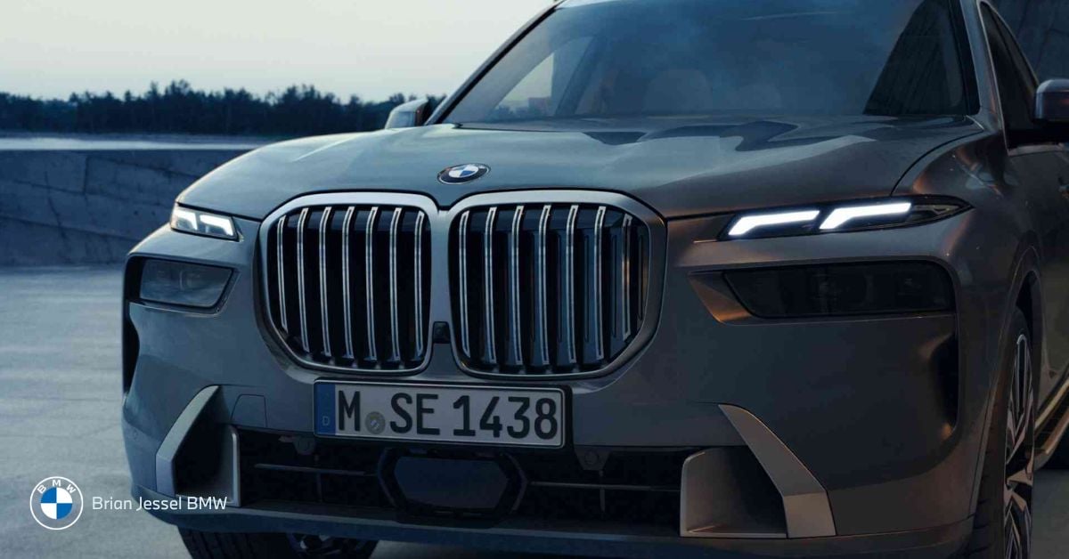 Front view of a BMW X7, showcasing its iconic grille and sleek design against dusk