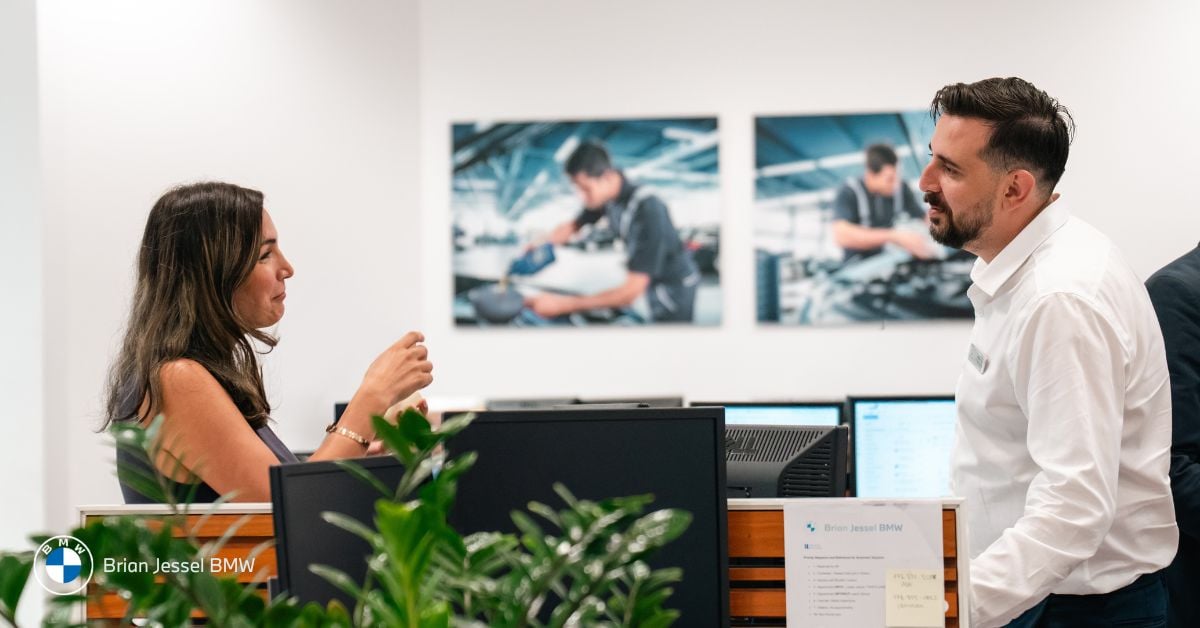 Customer and BMW representative engaging in conversation at the showroom, ready for a test drive