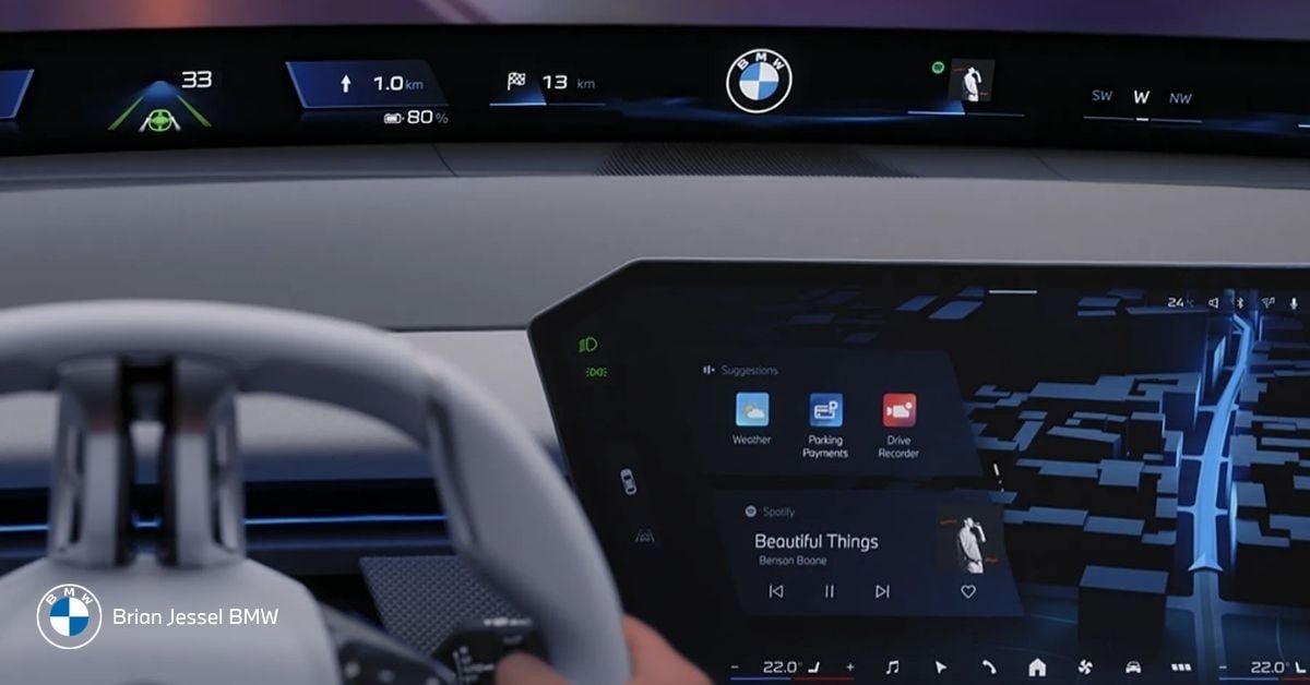 Modern BMW iDrive dashboard with panoramic curved display, navigation map, Spotify music, and driver assistance graphics