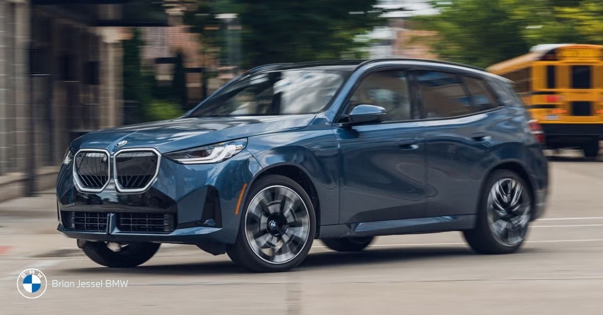 Blue BMW X3 xDrive driving on city street, side view, all-wheel-drive SUV, winter-ready, luxury compact vehicle.