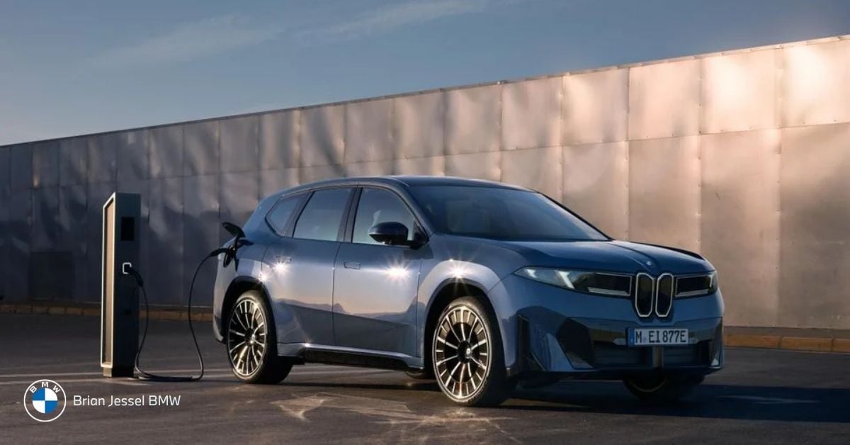 Blue BMW iX electric SUV charging at a station outdoors, showcasing modern luxury design at Brian Jessel BMW