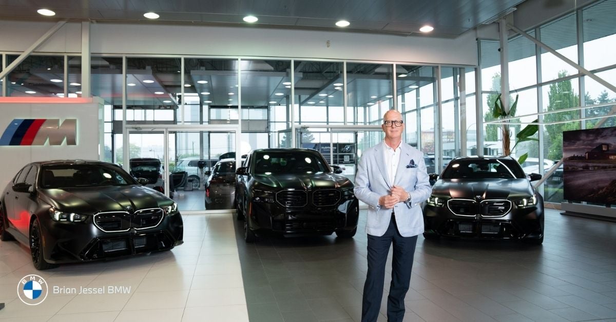 Brian Jessel BMW dealership interior in Vancouver featuring luxury black BMW electric vehicles and staff.