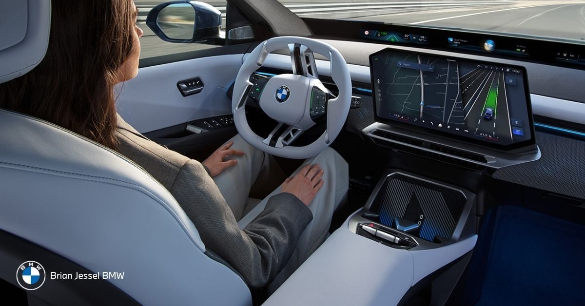 BMW driver using iDrive touchscreen and navigation with driver assistance, voice control, and connected features for daily commuting