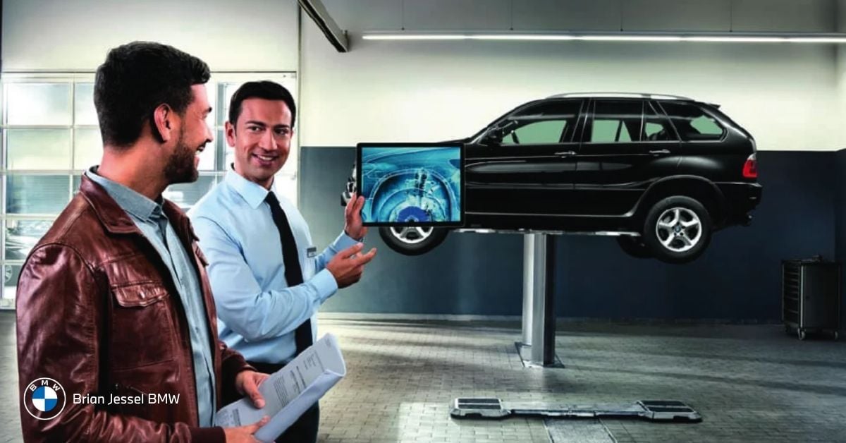 BMW dealership advisor reviewing vehicle appraisal and maintenance records with customer during BMW trade-in evaluation in Vancouver showroom.