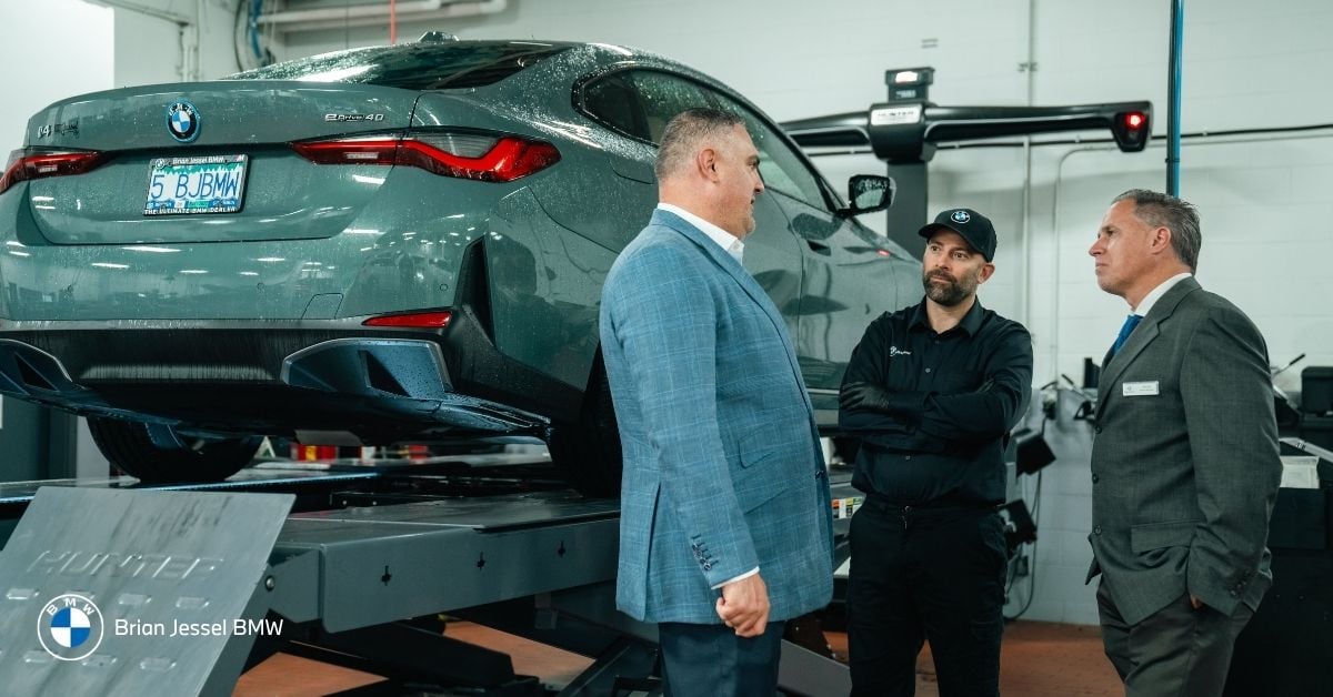 Brian Jessel BMW service team discussing BMW tire replacement, wheel alignment, and certified maintenance inside Vancouver service centre.