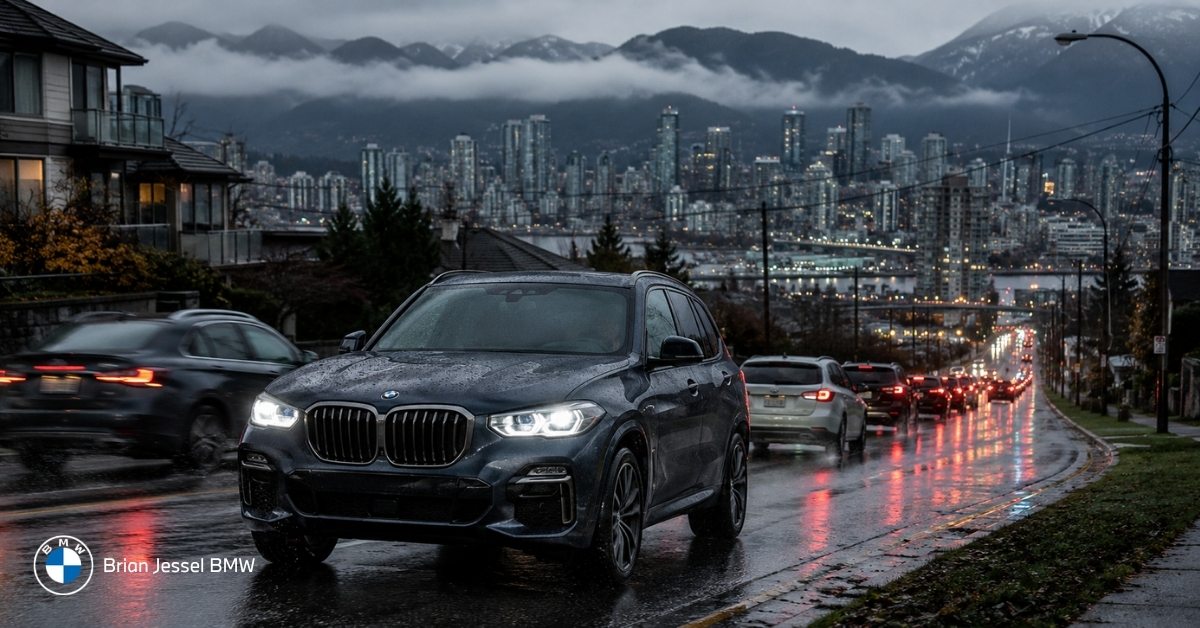 BMW SUV driving on rainy Vancouver street at dusk with glowing city and mountain backdrop, highlighting local driving conditions.