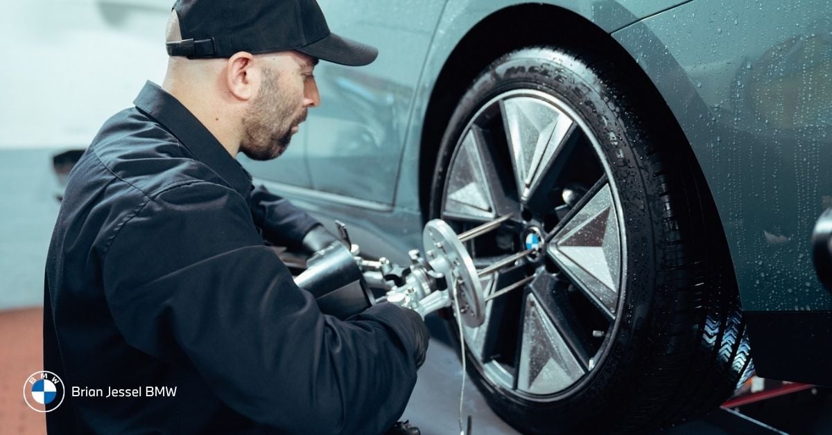 BMW technician aligns an i3 wheel using precision equipment during professional tire service at Vancouver dealership center.