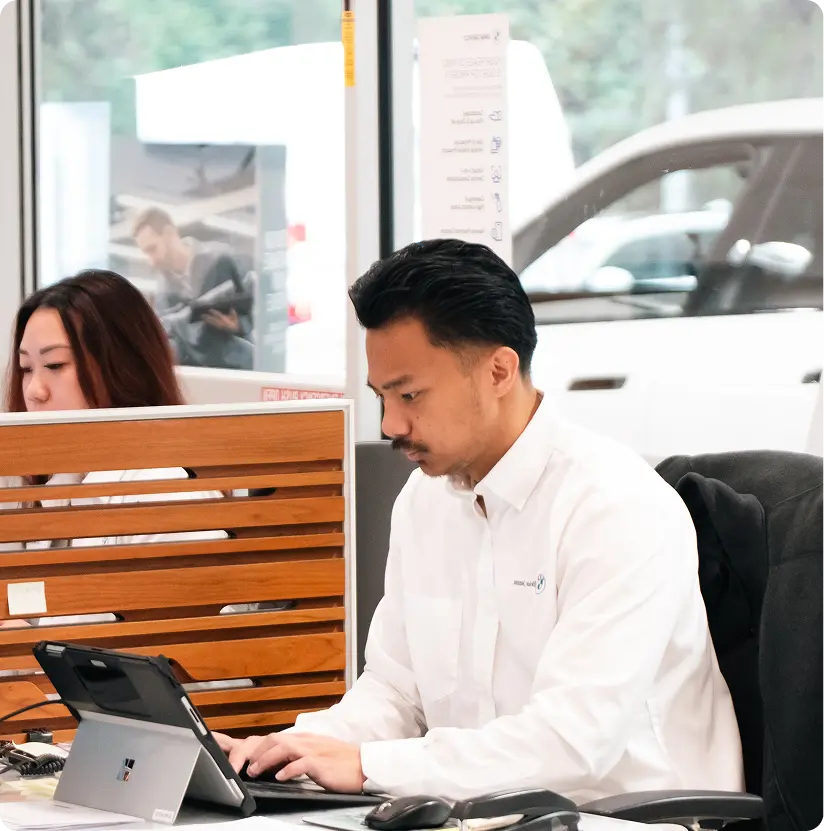 BMW advisor with laptop in the showroom