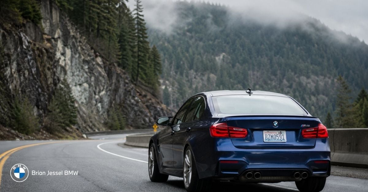 BMW M sedan drives along wet mountain road, illustrating practical performance settings for everyday driving.
