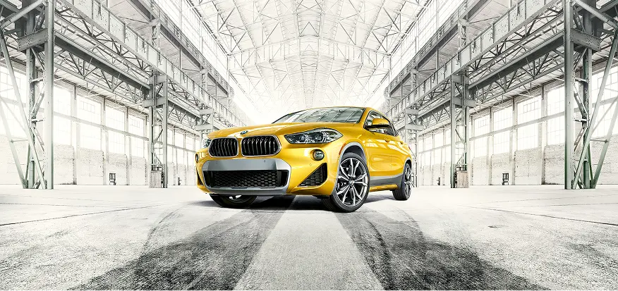 Yellow BMW X2 front view in a hangar