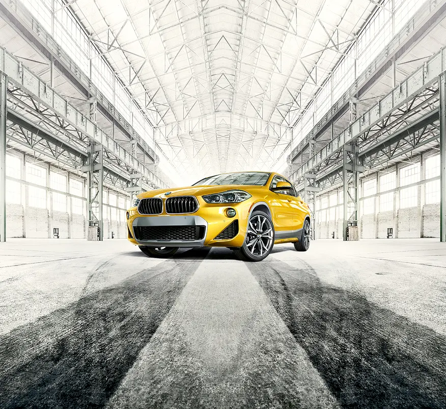 Yellow BMW X2 front view with tire marks