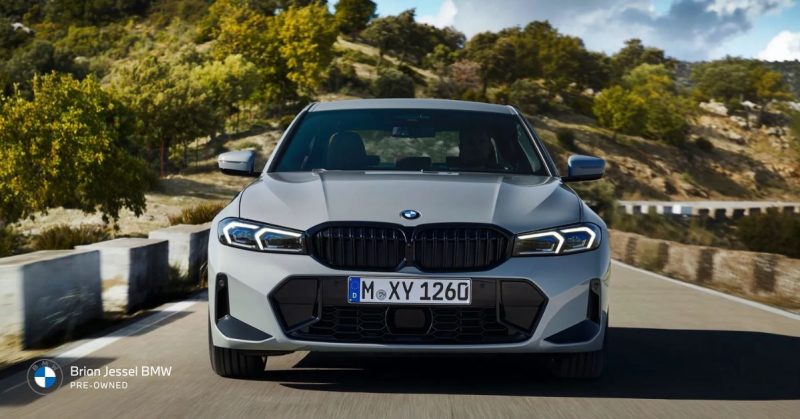Front view of a silver BMW sedan on a scenic road, emphasizing sporty design and customization possibilities