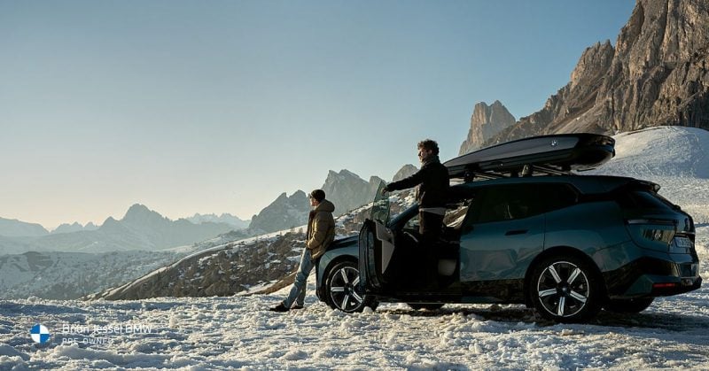 BMW X3 with rooftop cargo box, perfect for extra storage during winter adventures.