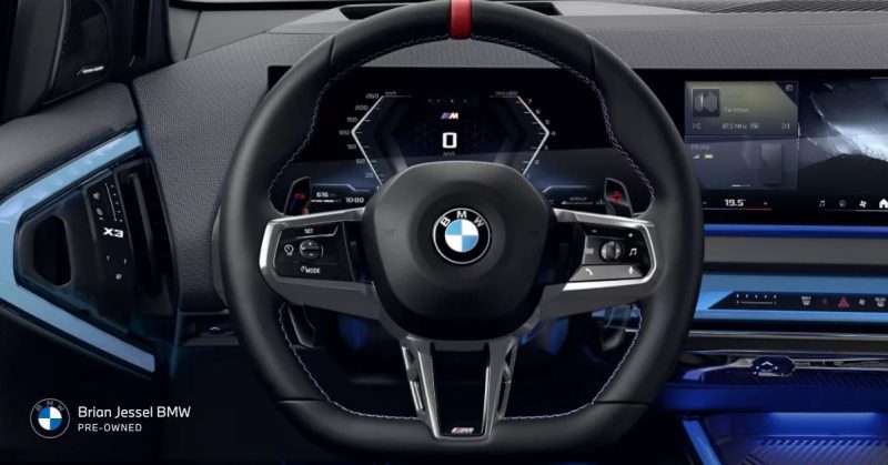 The interior of a BMW X3 showcasing its modern dashboard, digital display, and sporty steering wheel