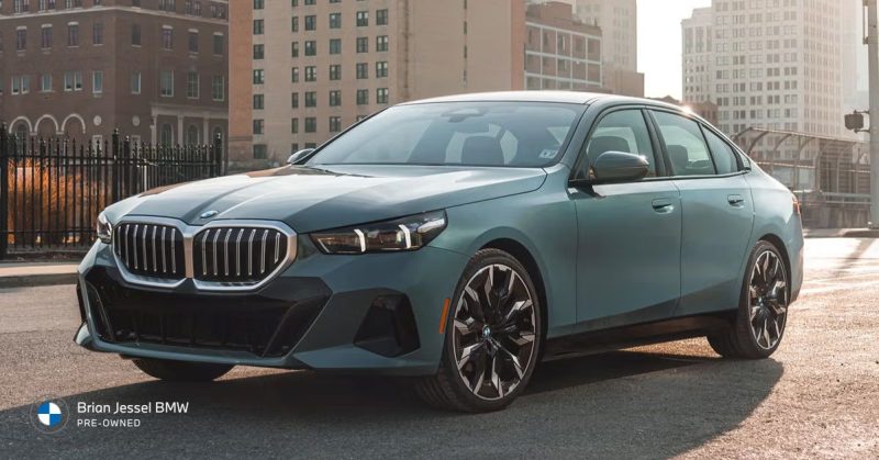 BMW 5 Series sedan parked in city setting, highlighting refined design and reputation for smooth, durable engine performance.