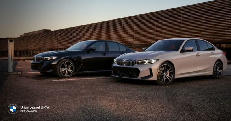 BMW 3 Series and 330e plug-in hybrid models parked next to charging station in city.