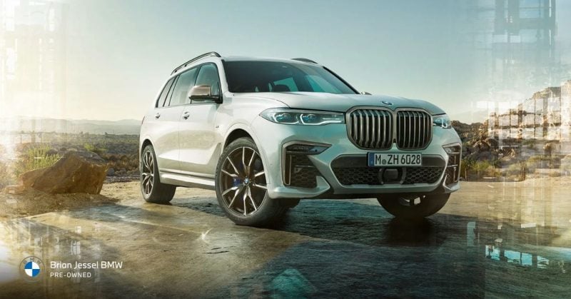 BMW X7 luxury SUV parked on a rugged terrain, showcasing a robust and stylish design.