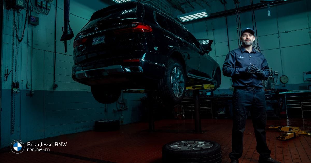 BMW technician inspects raised SUV in workshop, illustrating professional maintenance supporting long-term engine reliability principles.