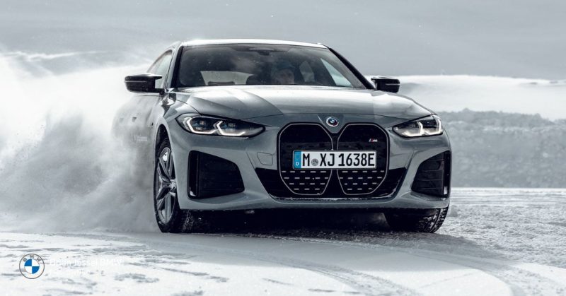 Grey BMW sedan driving on icy road, demonstrating controlled winter driving, safe braking, proper traction, and cautious handling in snowy conditions.