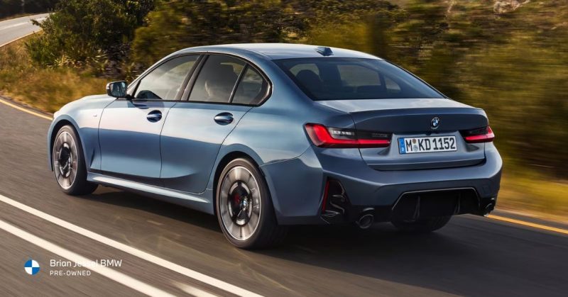 Blue BMW sedan driving on highway showcasing sporty design and enhanced performance features