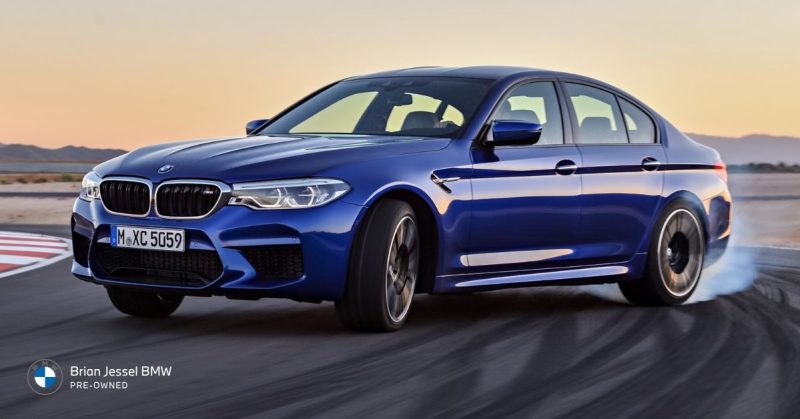 2018 BMW M5 blue sedan drifting on track, highlighting all-wheel drive traction, performance handling, and dynamic driving capability