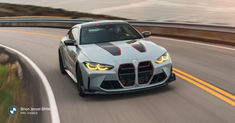 2023 BMW M4 CSL driving on winding road, lightweight track-focused coupe with aggressive styling and sharp handling performance