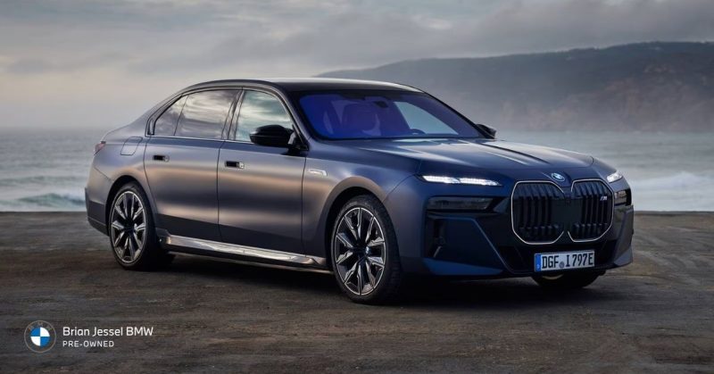 2024 BMW i7 M70 xDrive luxury electric sedan parked near coastline, showcasing large design, comfort, and performance presence