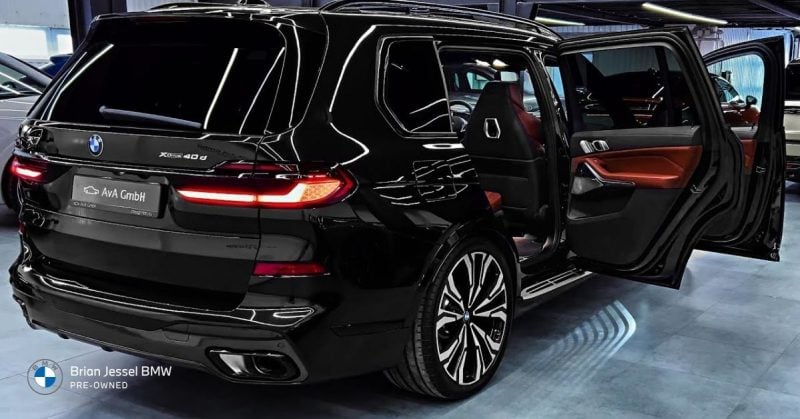 Rear view of glossy black BMW X5 pre-owned SUV highlighting space and style in dealership showroom