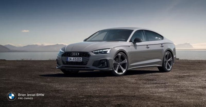 2024 Audi A5 parked beside coastal landscape, highlighting Quattro all-wheel drive, luxury styling, and refined pre-owned performance experience.