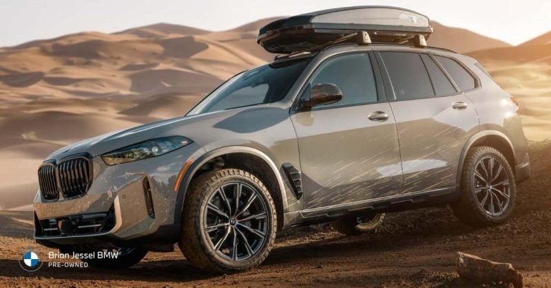 Pre-owned BMW SUV with xDrive system driving through desert terrain, showing capability for light off-road and adventure travel