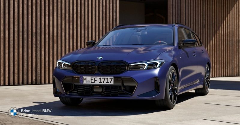 Blue BMW M340i xDrive parked in front of modern building, showcasing its sporty front design and sleek profile