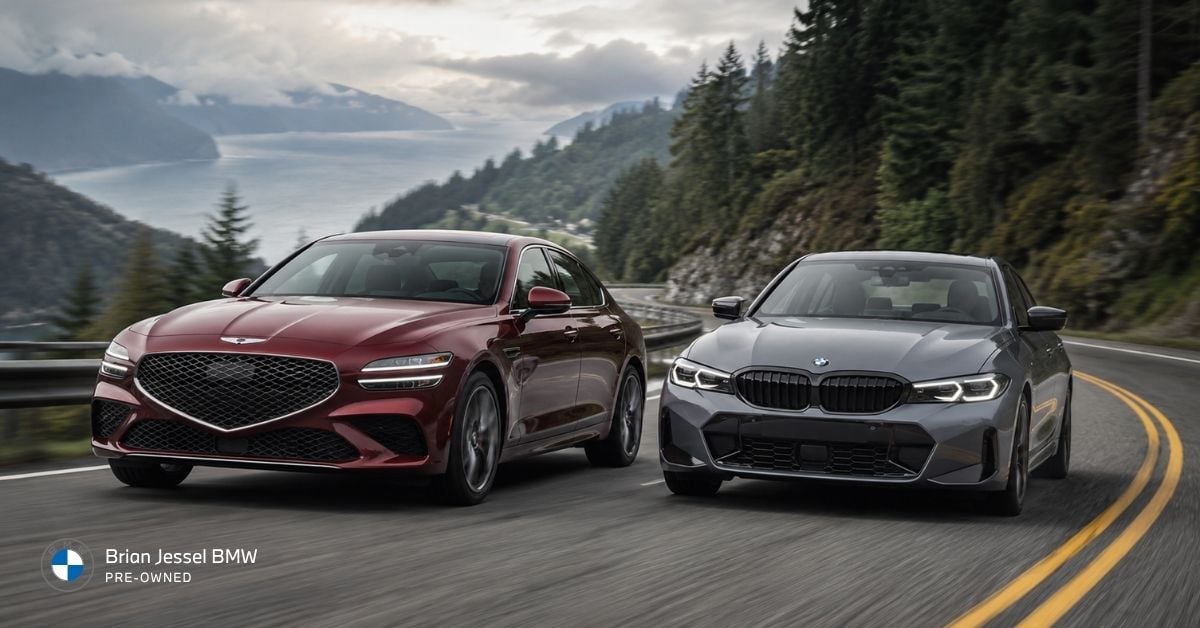 Genesis G70 and BMW 330i driving side by side on scenic coastal mountain road in performance comparison