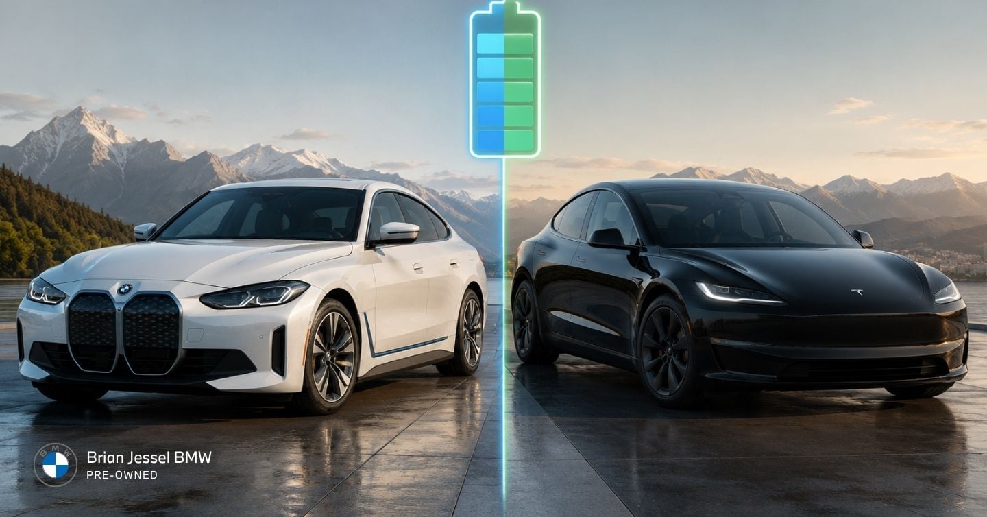 White BMW i4 and black Tesla Model 3 parked side-by-side beneath glowing battery icon against mountains.