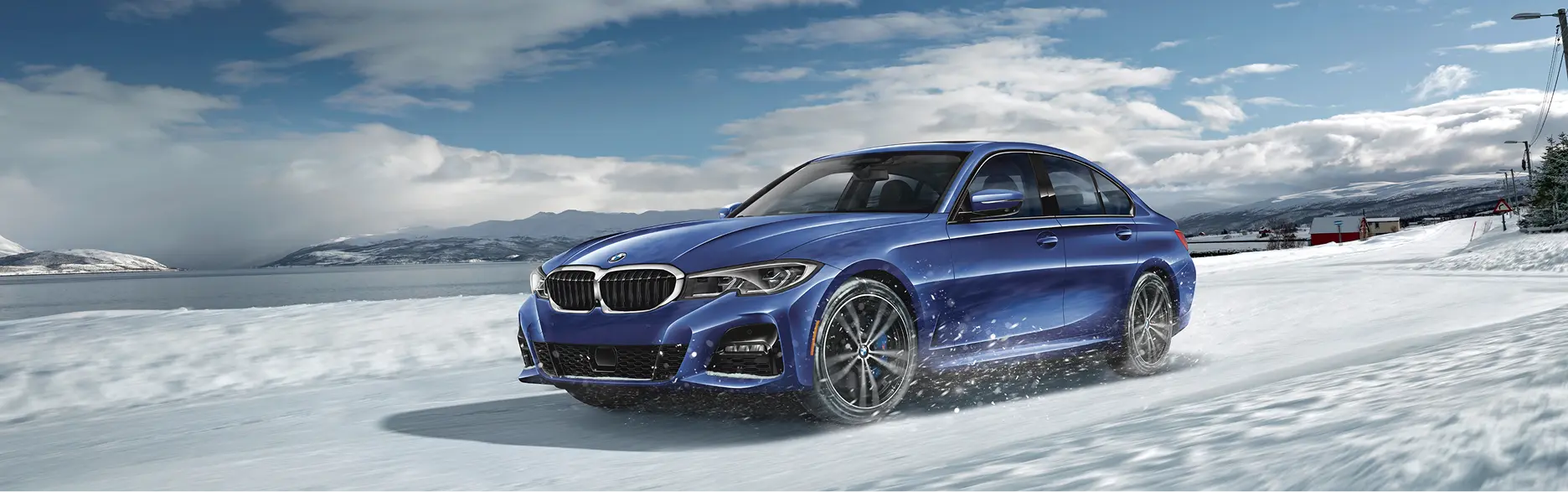 Blue BMW 330i driving on snow